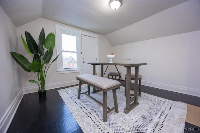 dining space with lofted ceiling and dark wood-type flooring