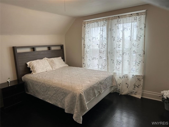 bedroom with vaulted ceiling and dark hardwood / wood-style floors