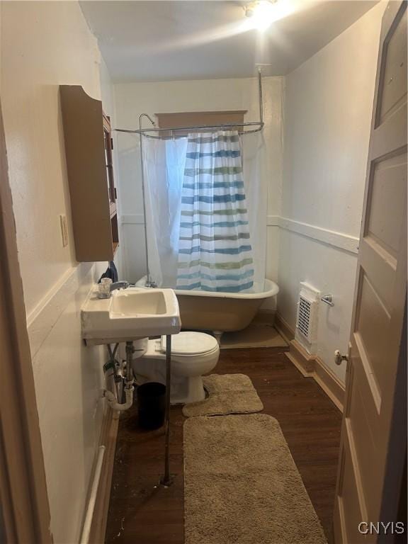 full bathroom with shower / tub combo with curtain, sink, hardwood / wood-style flooring, and toilet