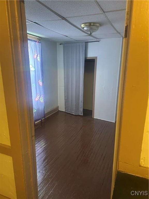 spare room featuring a paneled ceiling and dark hardwood / wood-style floors