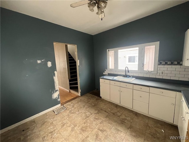 kitchen featuring tasteful backsplash, ceiling fan, sink, and white cabinets