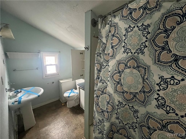 bathroom featuring lofted ceiling, a textured ceiling, tile patterned floors, toilet, and walk in shower