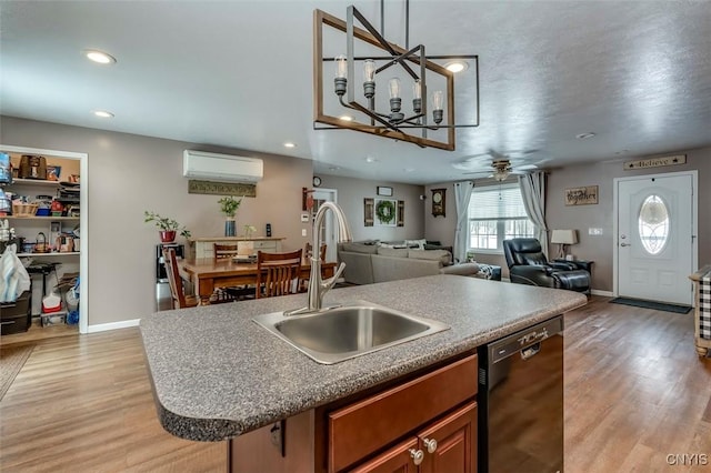 kitchen featuring sink, dishwasher, light hardwood / wood-style floors, a center island with sink, and an AC wall unit