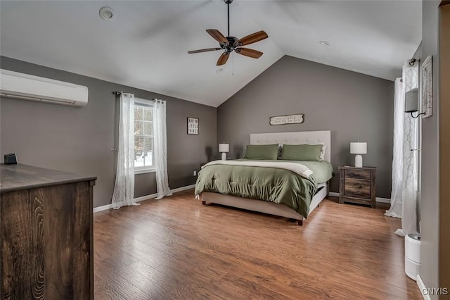 bedroom featuring lofted ceiling, ceiling fan, light hardwood / wood-style flooring, and a wall mounted AC