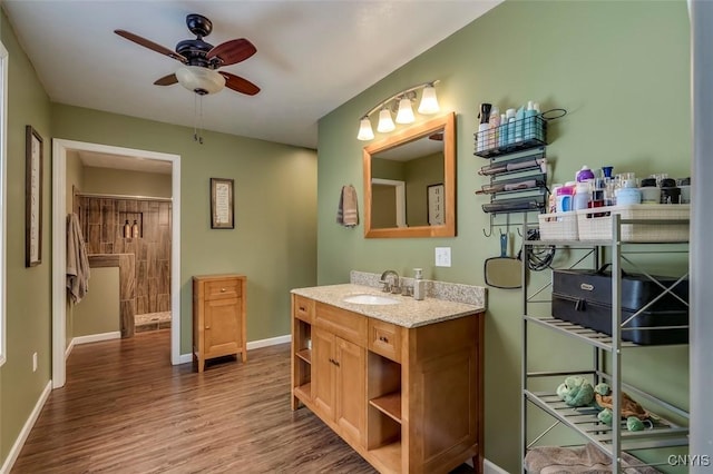 bathroom with hardwood / wood-style flooring, ceiling fan, and vanity