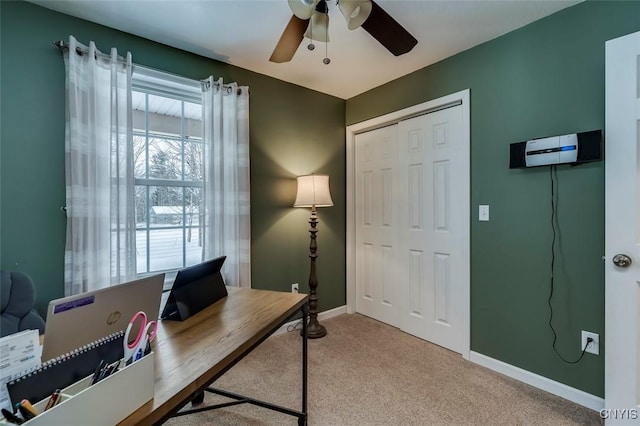 carpeted home office featuring an AC wall unit and ceiling fan