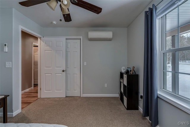 bedroom featuring a wall mounted air conditioner, light colored carpet, a closet, and ceiling fan