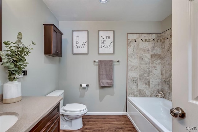 full bathroom featuring vanity, tiled shower / bath, hardwood / wood-style floors, and toilet