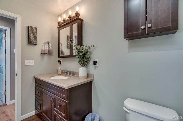 bathroom with vanity, toilet, and wood-type flooring