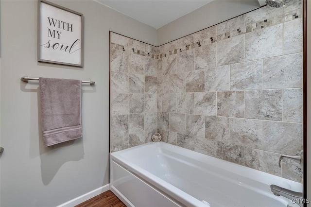 bathroom with hardwood / wood-style flooring and shower / washtub combination