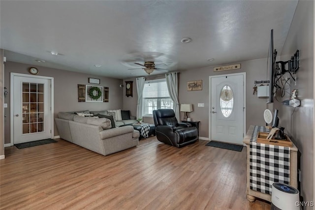 living room with ceiling fan and light hardwood / wood-style floors