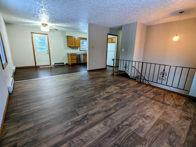 empty room with dark hardwood / wood-style flooring, a textured ceiling, and baseboard heating