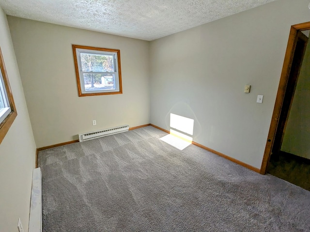 carpeted empty room with a baseboard heating unit and a textured ceiling