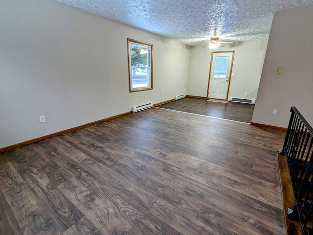 spare room featuring dark hardwood / wood-style flooring, a textured ceiling, and baseboard heating