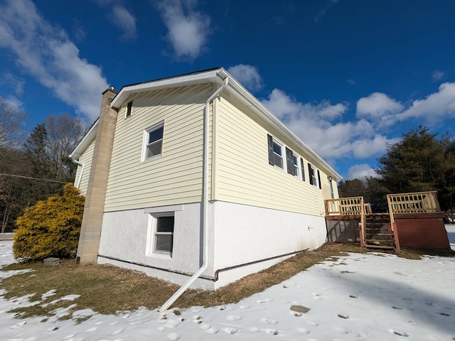 view of snowy exterior featuring a wooden deck