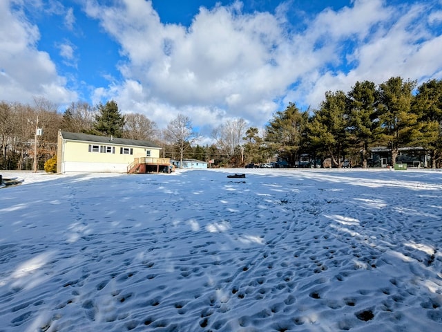 yard layered in snow with a deck