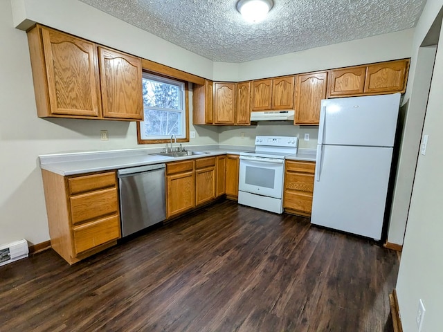 kitchen featuring sink, white appliances, dark wood-type flooring, and a textured ceiling