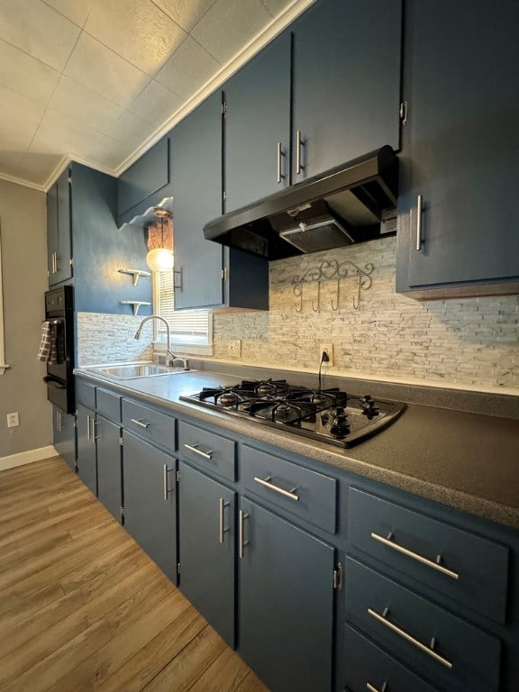 kitchen with stainless steel gas cooktop, sink, crown molding, tasteful backsplash, and wood-type flooring