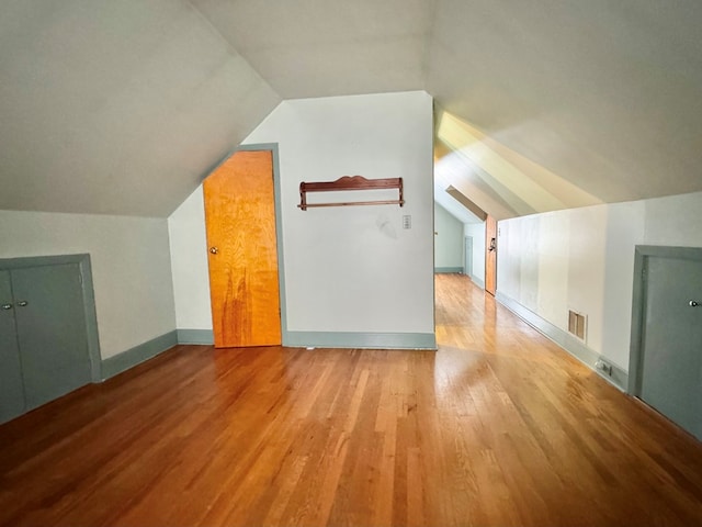 additional living space with lofted ceiling and light hardwood / wood-style floors