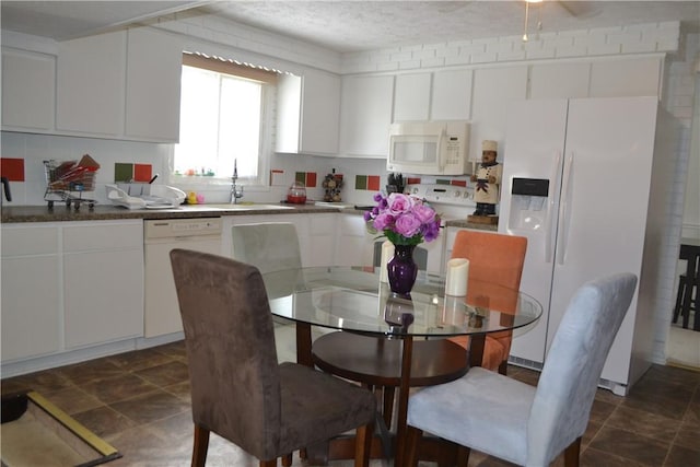 kitchen with white cabinetry, white appliances, sink, and a textured ceiling