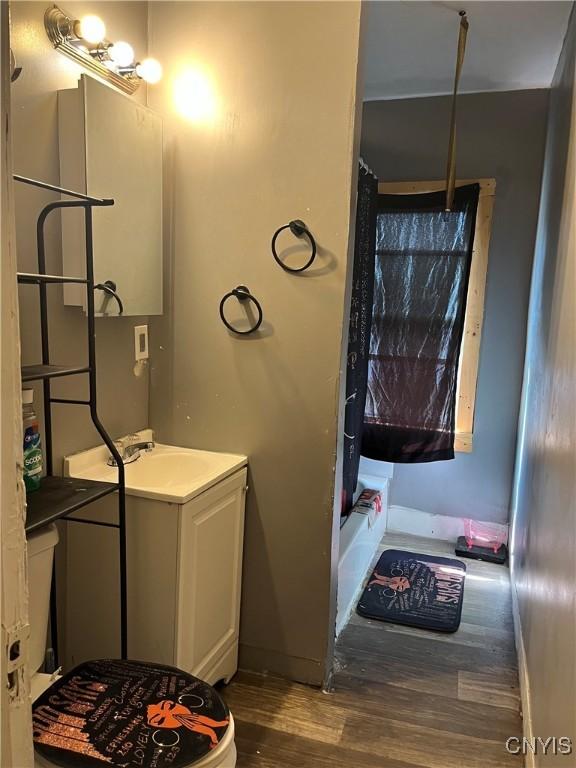 bathroom featuring vanity, hardwood / wood-style flooring, and shower / bath combo with shower curtain