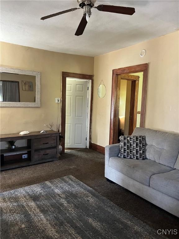 living room with ceiling fan and carpet flooring