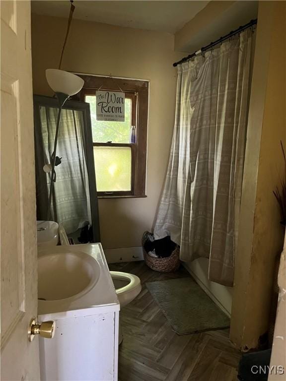 full bathroom with parquet flooring, vanity, toilet, and shower / tub combo