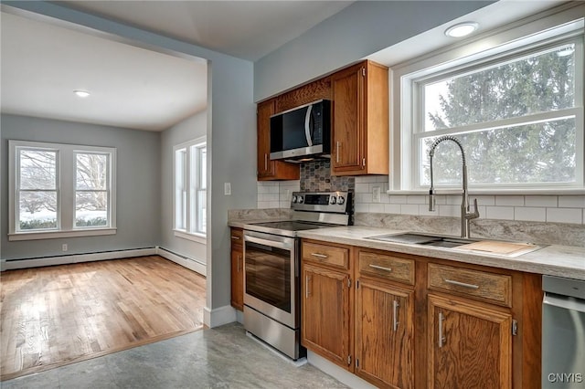 kitchen featuring tasteful backsplash, a healthy amount of sunlight, sink, and electric range