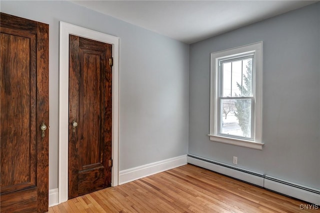 spare room with light hardwood / wood-style flooring and a baseboard heating unit