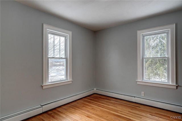 unfurnished room with light hardwood / wood-style floors, a healthy amount of sunlight, and baseboard heating