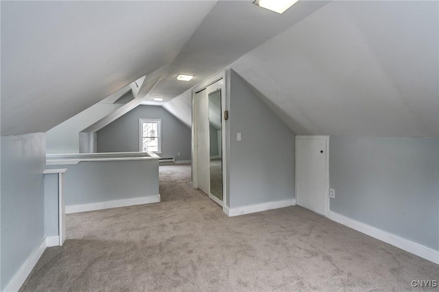 bonus room featuring vaulted ceiling, light colored carpet, and a baseboard radiator