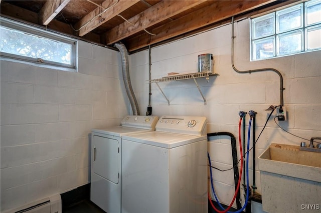 laundry area featuring a baseboard radiator, washer and clothes dryer, and sink