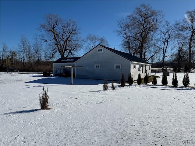 view of snow covered back of property