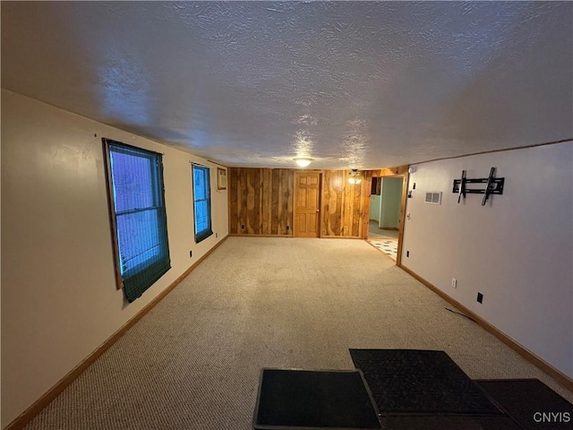 spare room featuring light carpet and a textured ceiling