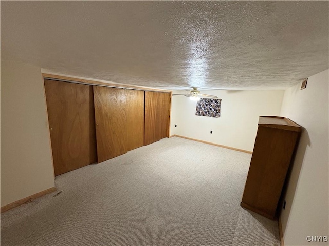 bonus room featuring light colored carpet and a textured ceiling