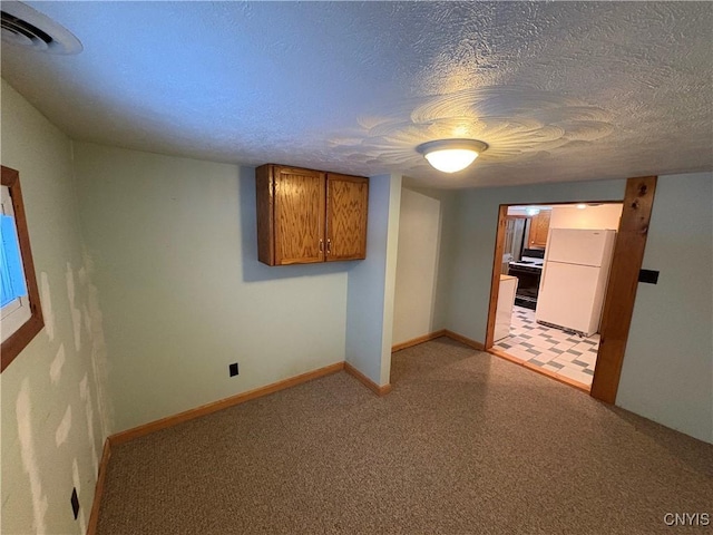 carpeted empty room featuring a textured ceiling