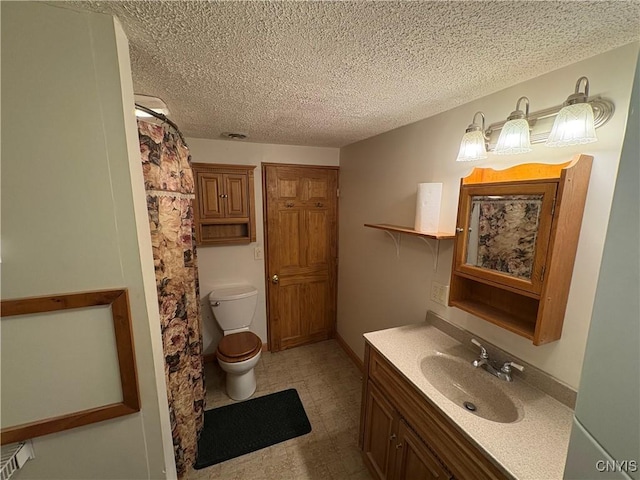 bathroom featuring vanity, toilet, and a textured ceiling