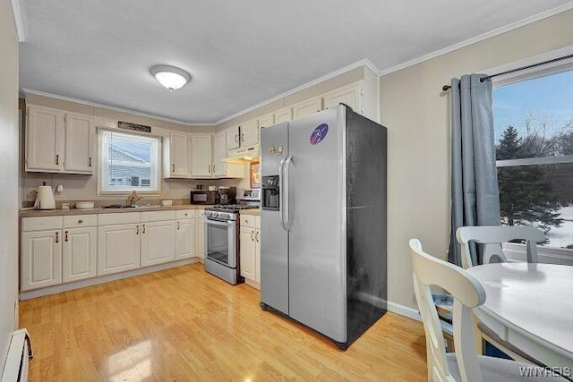 kitchen featuring crown molding, a baseboard radiator, appliances with stainless steel finishes, and light hardwood / wood-style floors