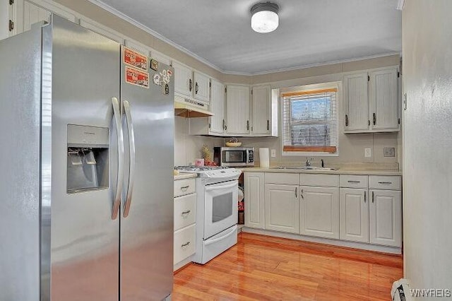 kitchen featuring sink, light hardwood / wood-style flooring, ornamental molding, appliances with stainless steel finishes, and white cabinets