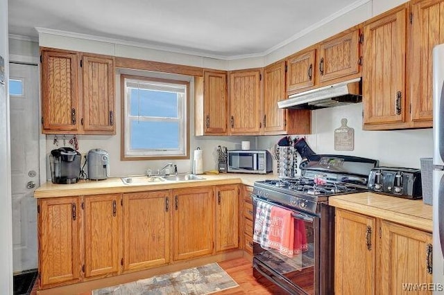 kitchen featuring crown molding, sink, black gas range, and light wood-type flooring