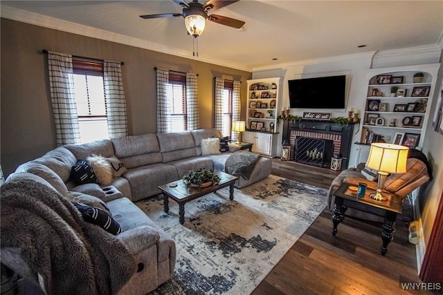 living room featuring ceiling fan, a fireplace, ornamental molding, and dark hardwood / wood-style flooring