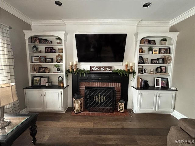 living room featuring dark wood-type flooring, crown molding, built in shelves, and a brick fireplace