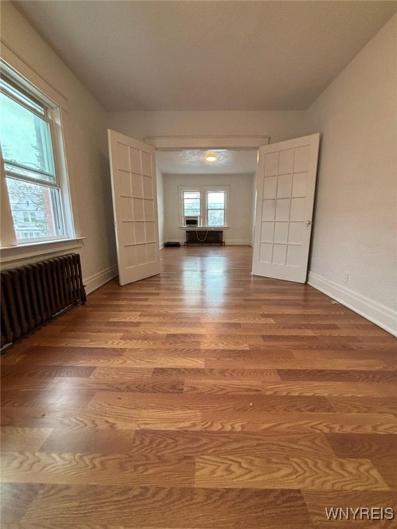 unfurnished room with hardwood / wood-style flooring and radiator