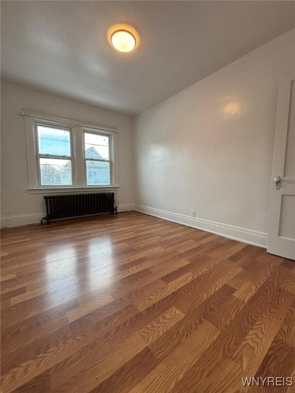 spare room with wood-type flooring and radiator