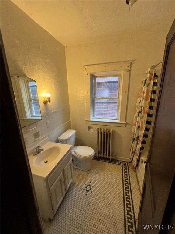 bathroom with radiator heating unit, toilet, curtained shower, and vanity