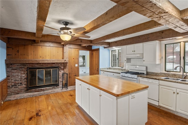 kitchen with white cabinetry, a kitchen island, sink, and white appliances