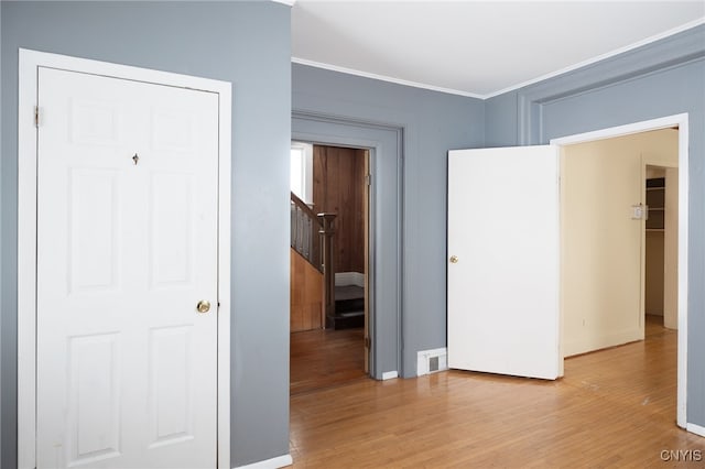 interior space with ornamental molding and light hardwood / wood-style flooring