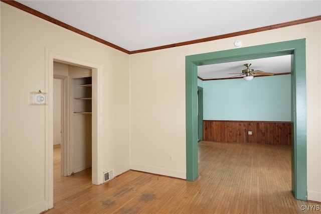 unfurnished room featuring crown molding, light hardwood / wood-style flooring, and ceiling fan