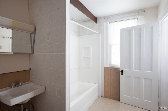 bathroom featuring shower / tub combination, sink, and tile walls