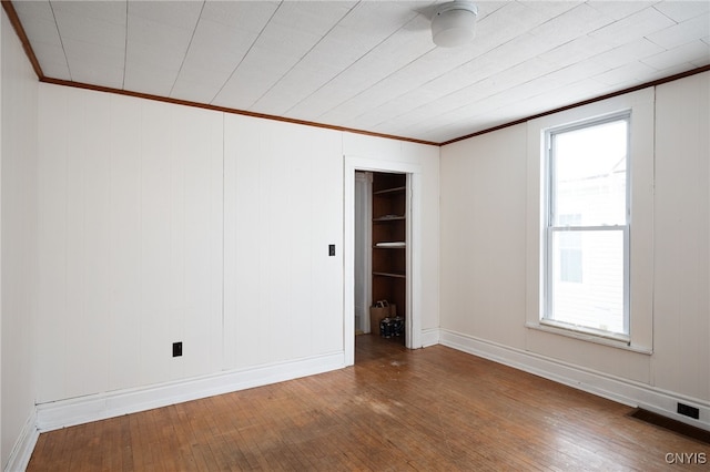 unfurnished room with hardwood / wood-style flooring and ornamental molding